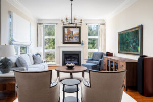 Frame tv, walnut console, circular table, beige chair, modern light, fire place, custom window treatments, interior design in maryland