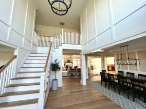 Foyer with custom millwork, stairs, and runner