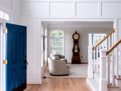 Foyer interior design in Maryland showing a custom millwork, blue door, white oak floors, custom rug.