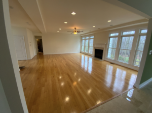 Large empty room with large windows and fireplace.