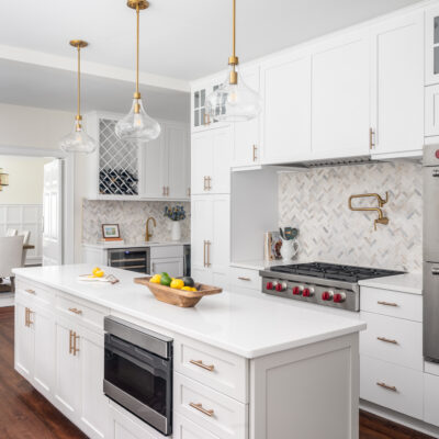 Beautifully renovated kitchen with Wolf and Sub-Zero appliances, glass pendants, and marble backsplash.