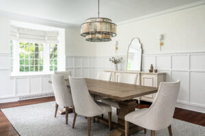 Timeless dining room with custom millwork, beautiful lighting, and large dining table.