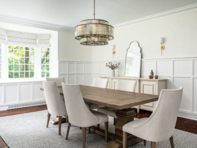 Timeless dining room with custom millwork, beautiful lighting, and large dining table.