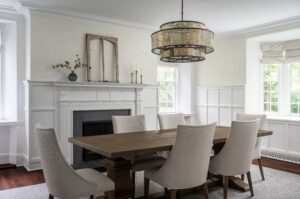Modern chandelier over a Mcgee and Co style dining table, custom rug, wainscotting.