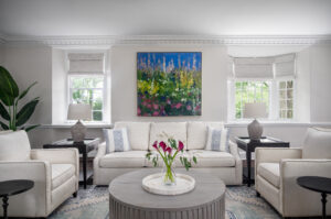 Elegant Parlor used for entertaining guests. Adorned with light furnishings and a bold, colorful painting 