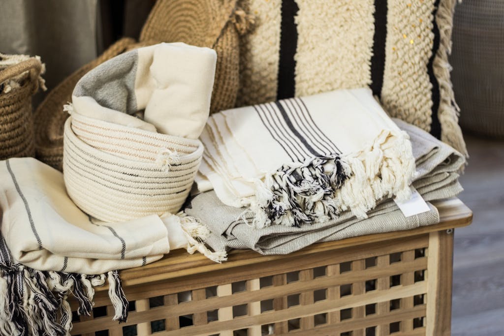 A collection of soft linens and woven baskets neatly stacked indoors.