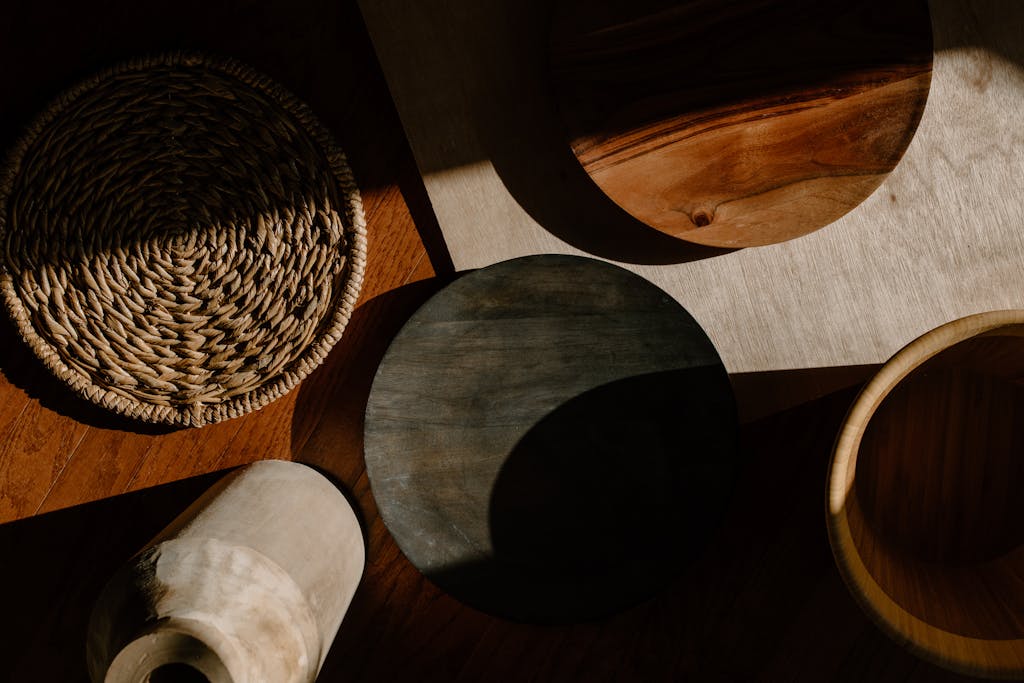 A flat lay of wooden kitchen utensils and woven materials in warm natural lighting, showcasing minimalist design.