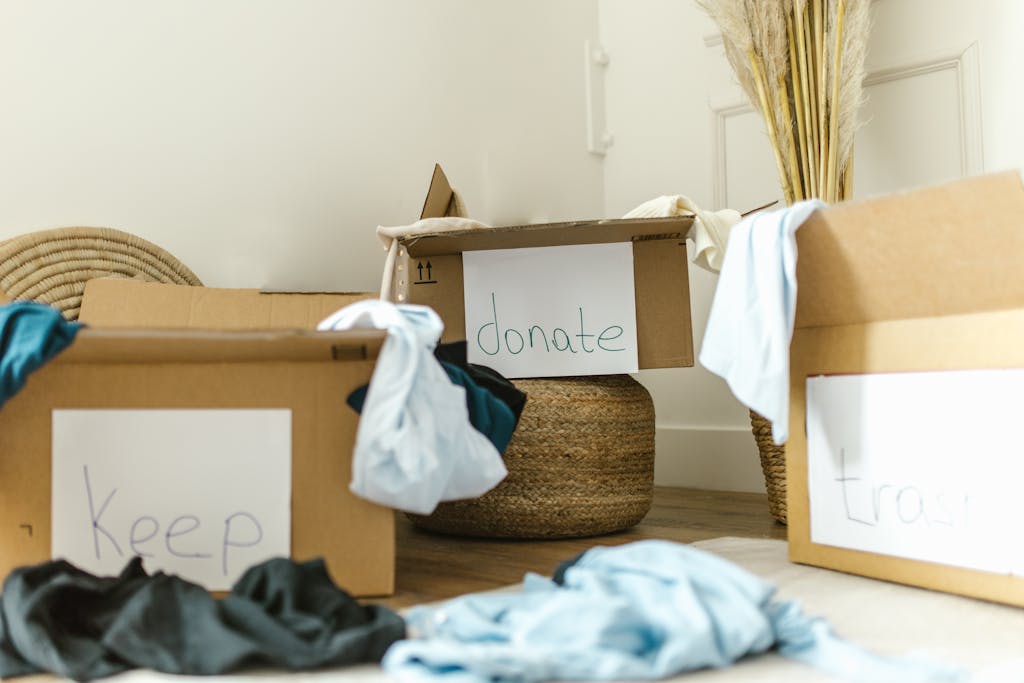 Cardboard boxes labeled keep, donate, and trash for effective home organization.