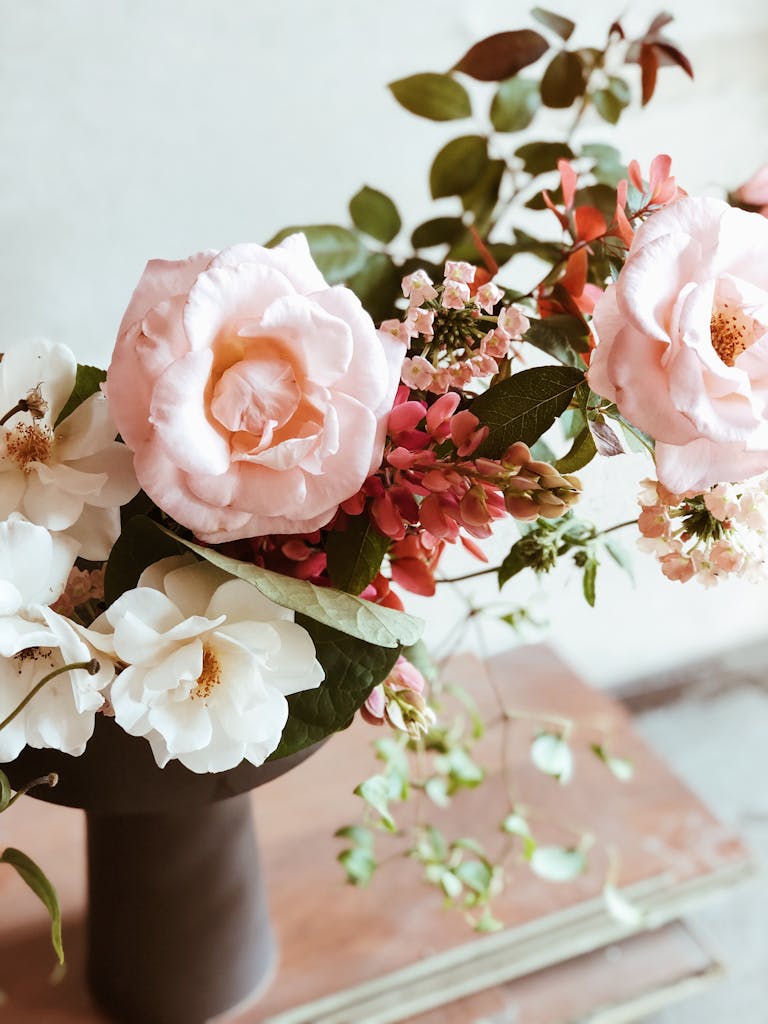 Charming floral arrangement featuring soft pink and white roses in an elegant vase, perfect for romantic occasions.