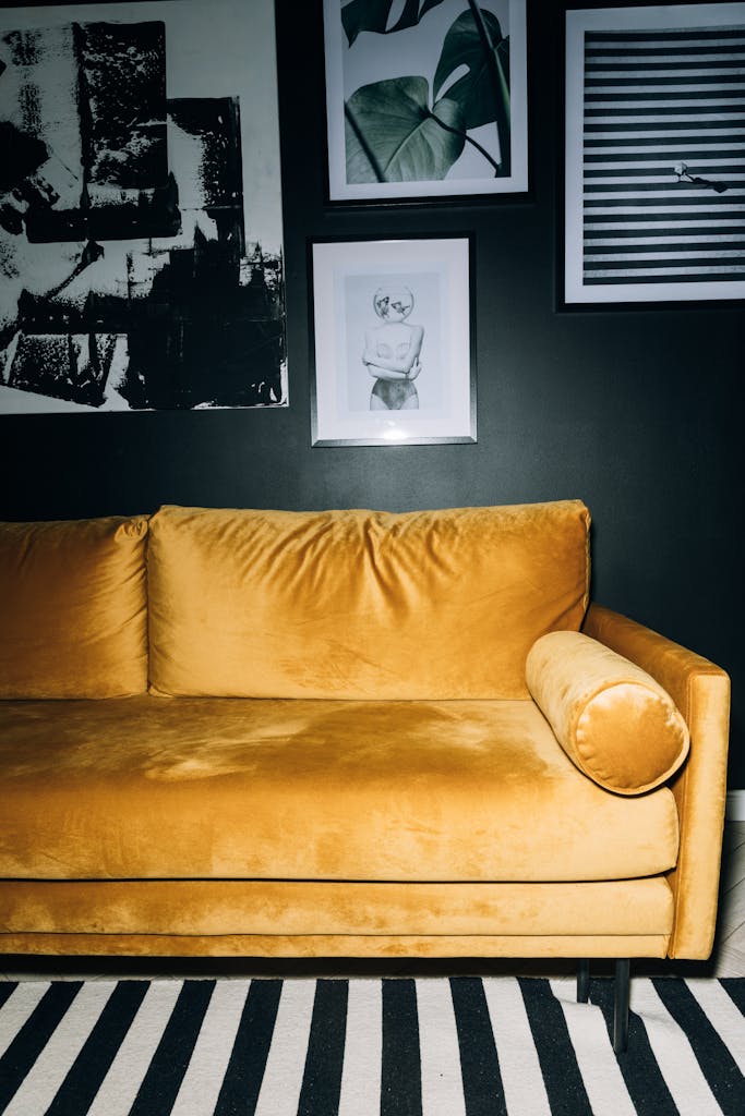 Chic living room featuring a yellow velvet sofa with contemporary art on the wall.