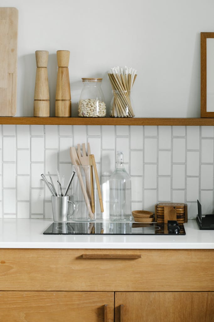 Contemporary kitchen with wooden accessories and white tile backsplash for a sleek, minimalist aesthetic.