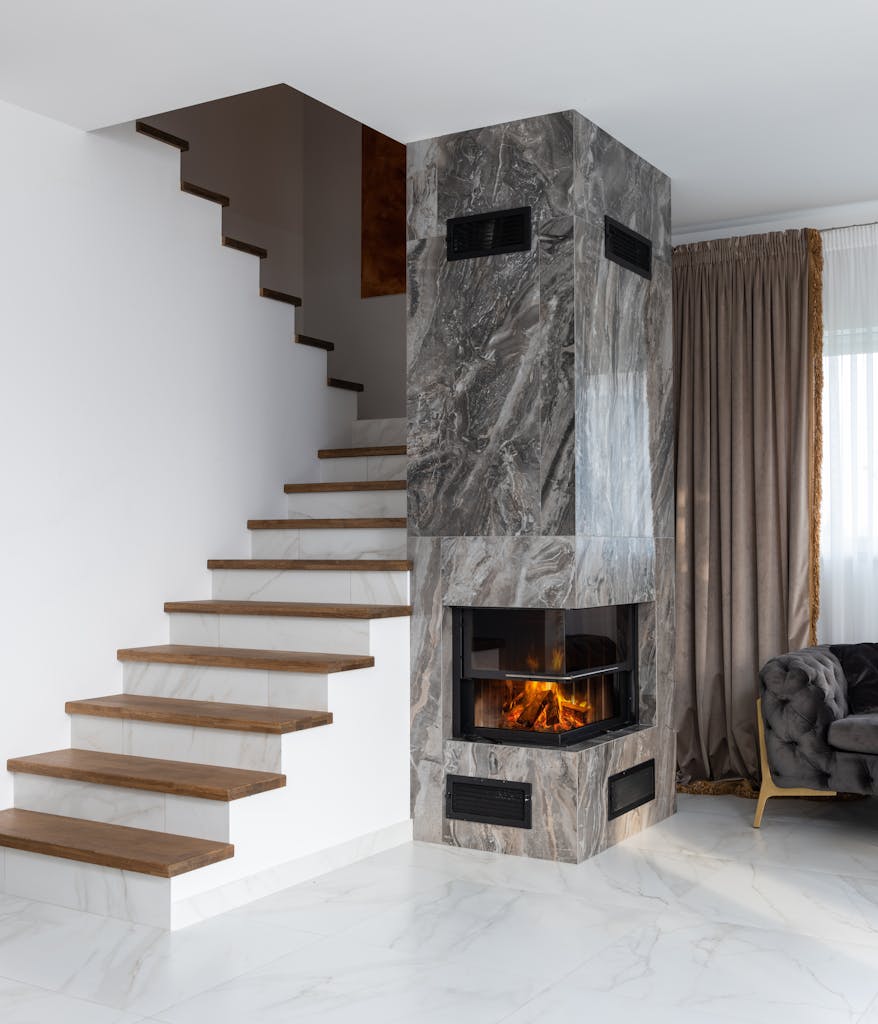 Elegant interior featuring a marble-textured fireplace and wooden staircase.