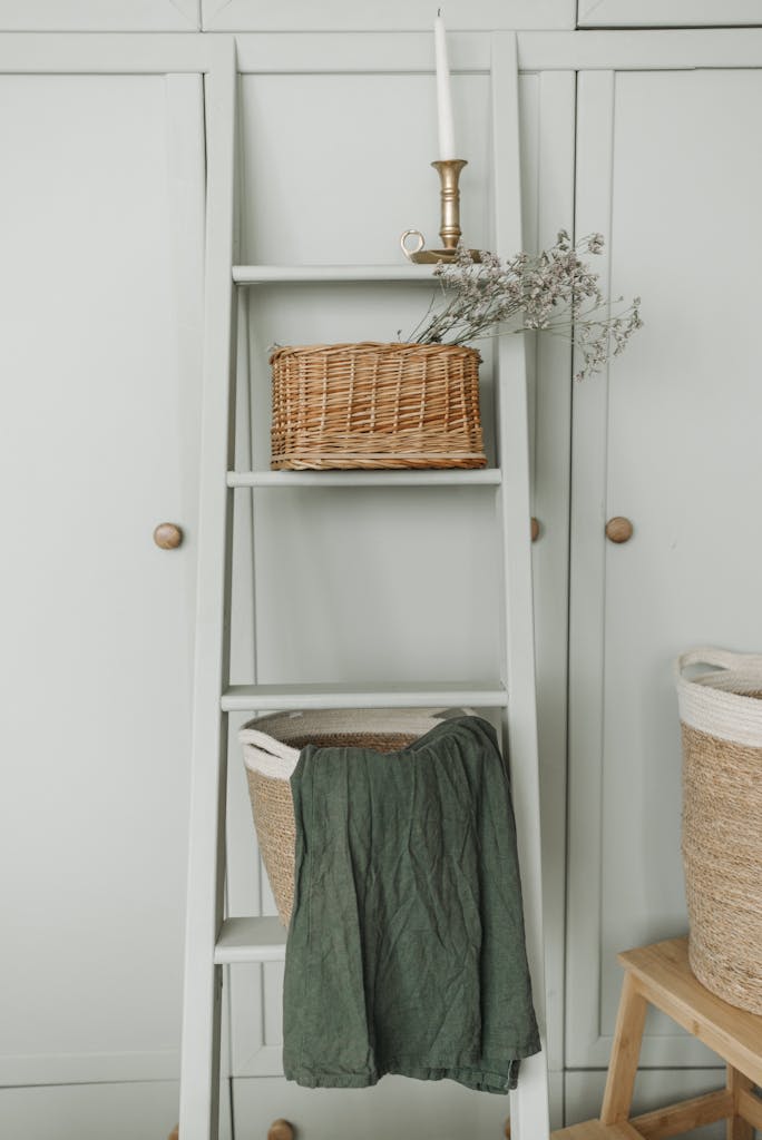 Elegant interior with wicker baskets, a ladder, and candle for a vintage look.