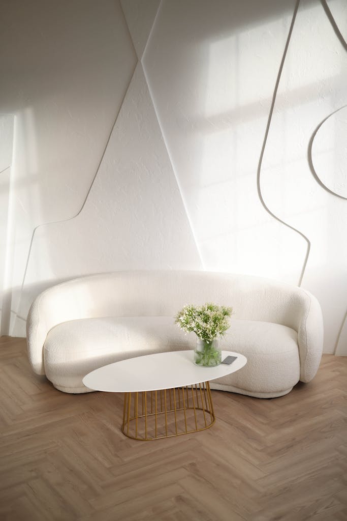 Elegant living room with a sleek white sofa, stylish table, and soft lighting.