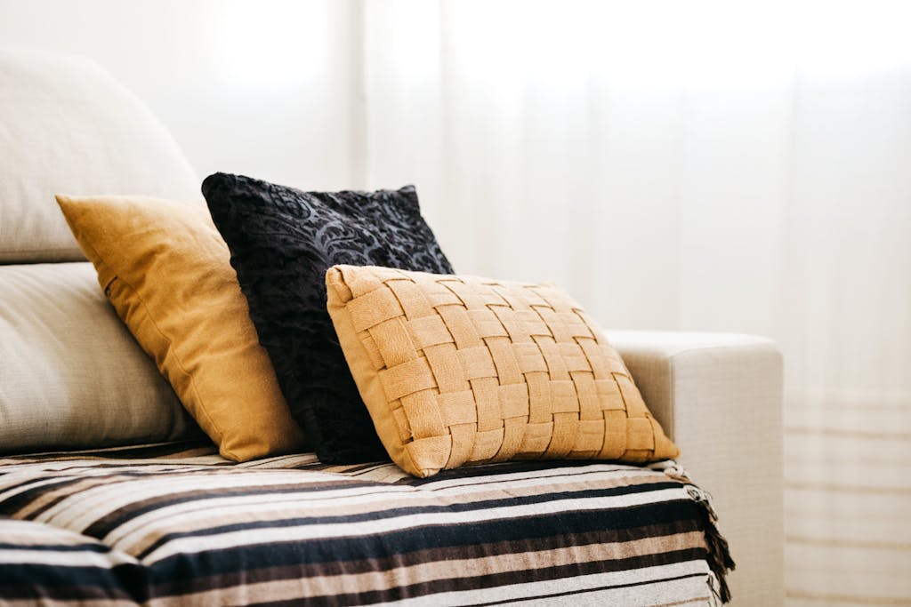 Modern interior design featuring a comfortable sofa with decorative pillows and a striped throw.