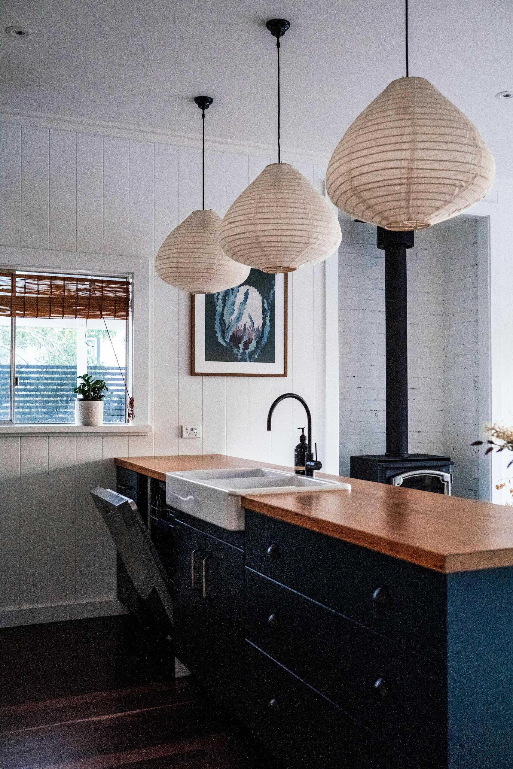 Stylish kitchen design featuring wooden countertops and artistic lighting, creating a cozy ambiance.