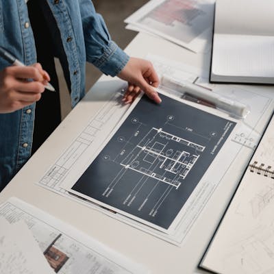 Engineer reviewing architectural blueprints on a desk with technical drawings.