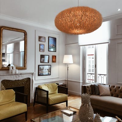 Chic living room in Paris featuring stylish furniture, elegant chandelier, and modern decor.